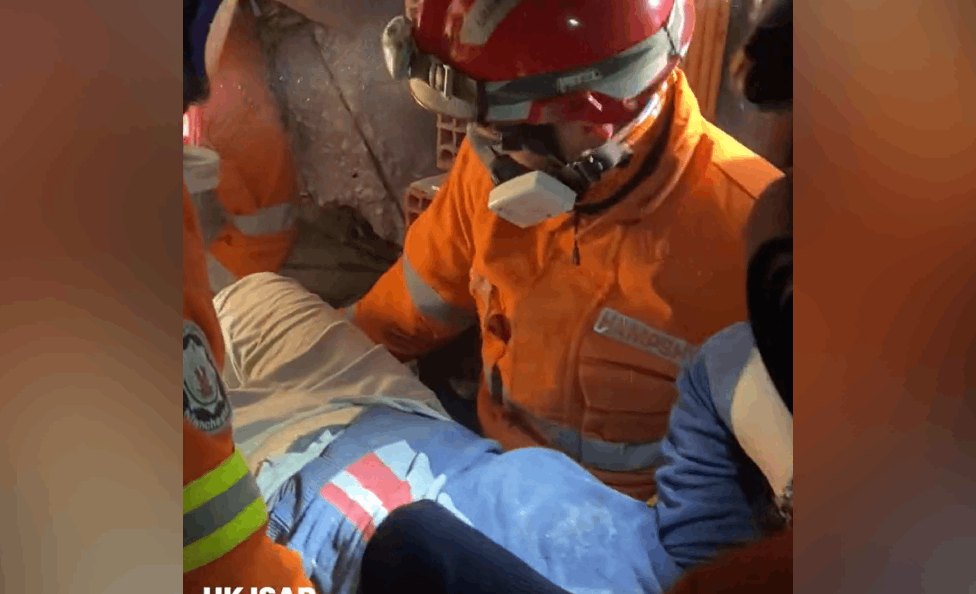 عامل الإطفاء فيل إيرفينغ خلال إنقاذه شخصين من ركام الزلزال في تركيا