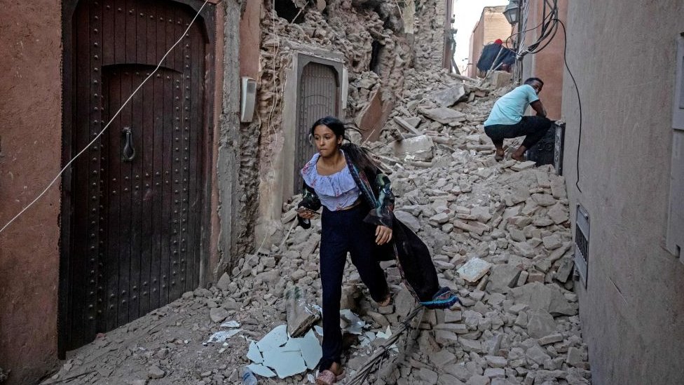 شابة تقوم بإخراج أمتعتها من بين الأنقاض في مدينة مراكش القديمة المتضررة من الزلزال