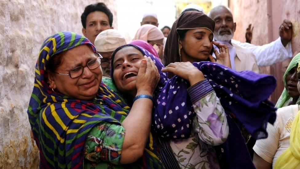 Родственники оплакивают убитого индийского жителя Мохаммада Ахлака в деревне Бисада, примерно в 35 километрах (22 милях) к северо-востоку от Нью-Дели,