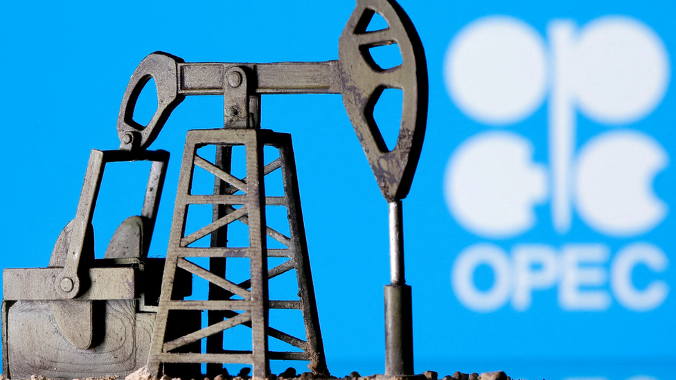 Una reproducción 3D de un balancín petrolero frente a un letrero de la OPEP.