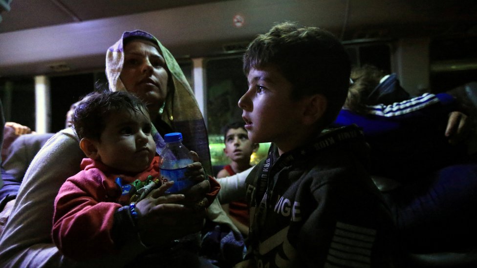 Сирийские перемещенные семьи, бежавшие от насилия после турецкого наступления на Сирию, сидят в автобусе после прибытия в лагерь беженцев в Бардараше на окраине Дохука, Ирак 17 октября,