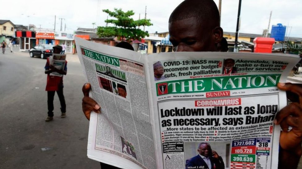 Мужчина читает газету на улице Лагос
