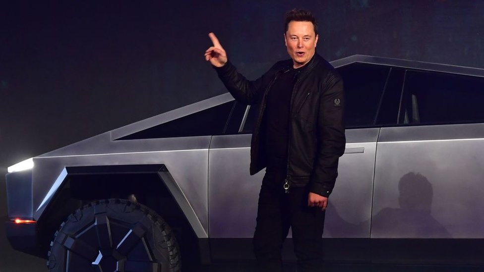 Elon Musk y uno de los autos de Tesla.