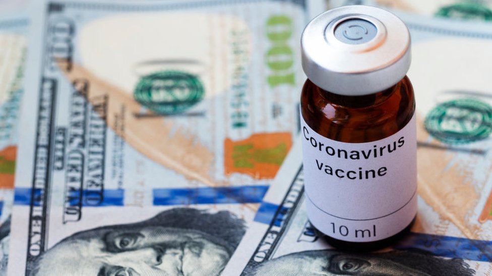 UKRAINE - 2020/04/08: In this photo illustration a vial labelled Coronavirus vaccine seen displayed on one hundred US dollar banknotes.