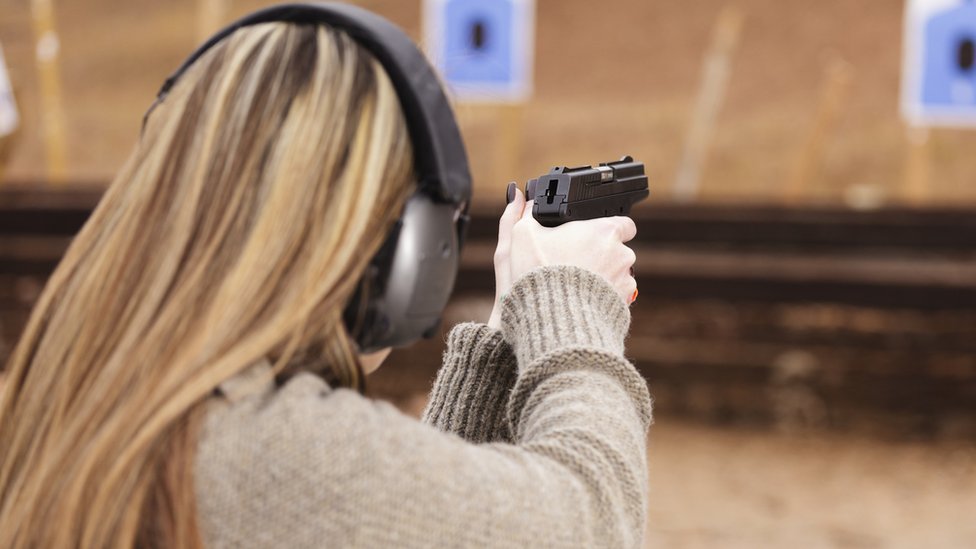 Женщина стреляет из пистолета