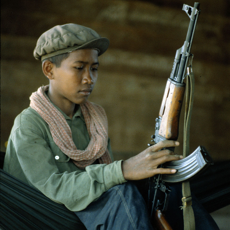 Niño soldado jemer rojo con rifle