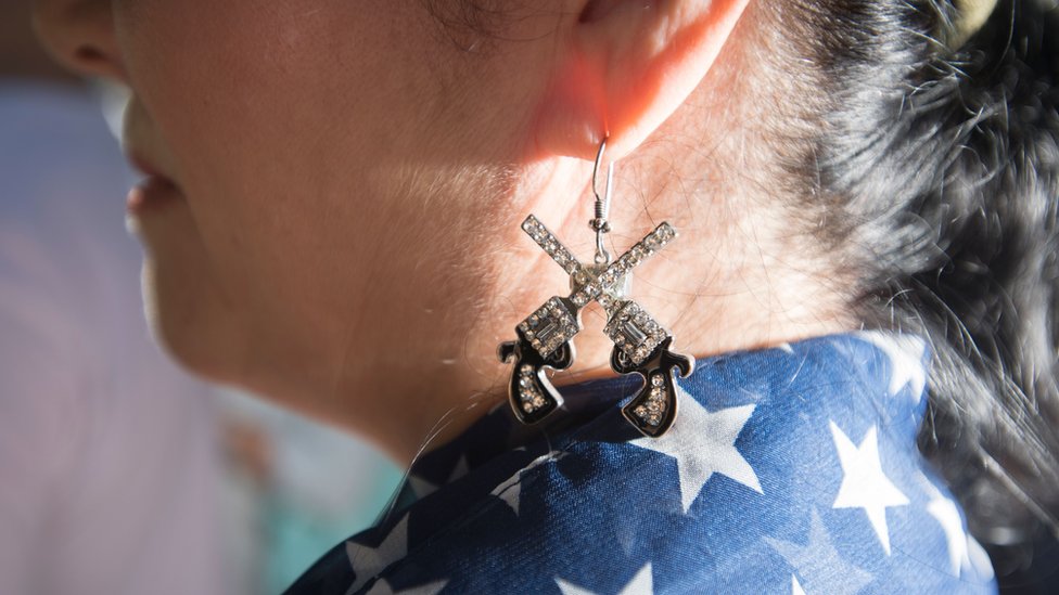 woman with gun earrings