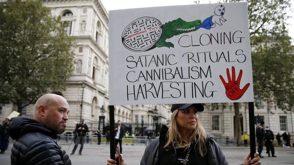 Протестующий держит плакат во время митинга «Спасем наших детей» возле Даунинг-стрит 10 октября 2020 года в Лондоне,