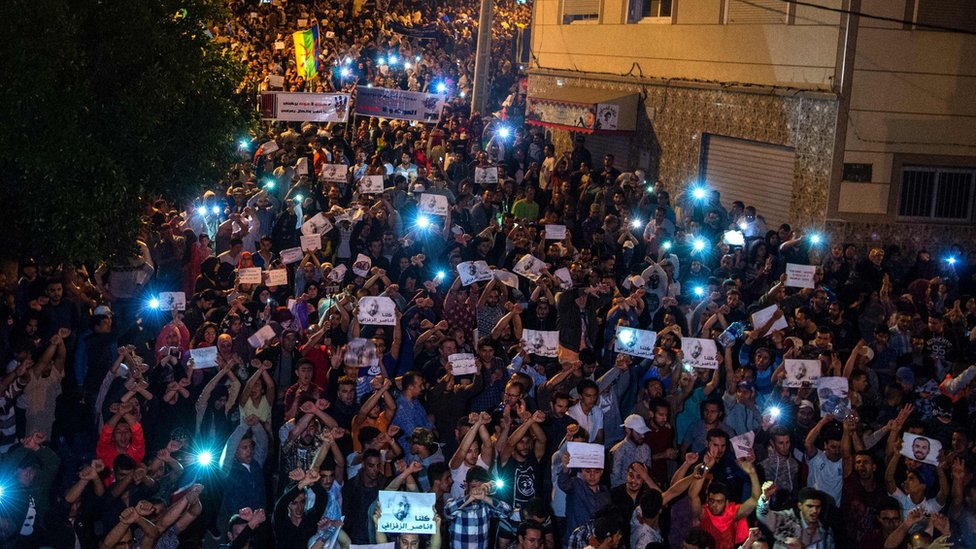 Демонстранты держат фотографии Насера ??Зафзафи во время демонстрации в северном городе Эль-Хосейма 30 мая 2017 г.