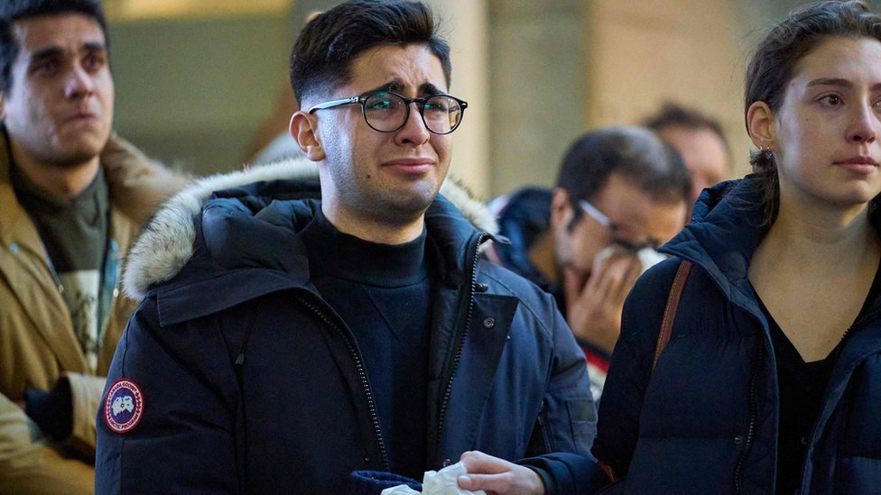 Мужчина плачет во время службы в Западном университете для четырех аспирантов, погибших в авиакатастрофе