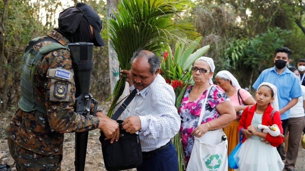 A soldier searches people at a checkpoint in El Salvador, April 4, 2022.