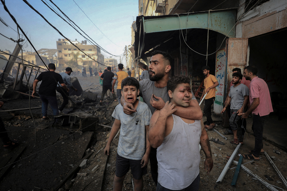 Man with two boys amid damage in Gaza