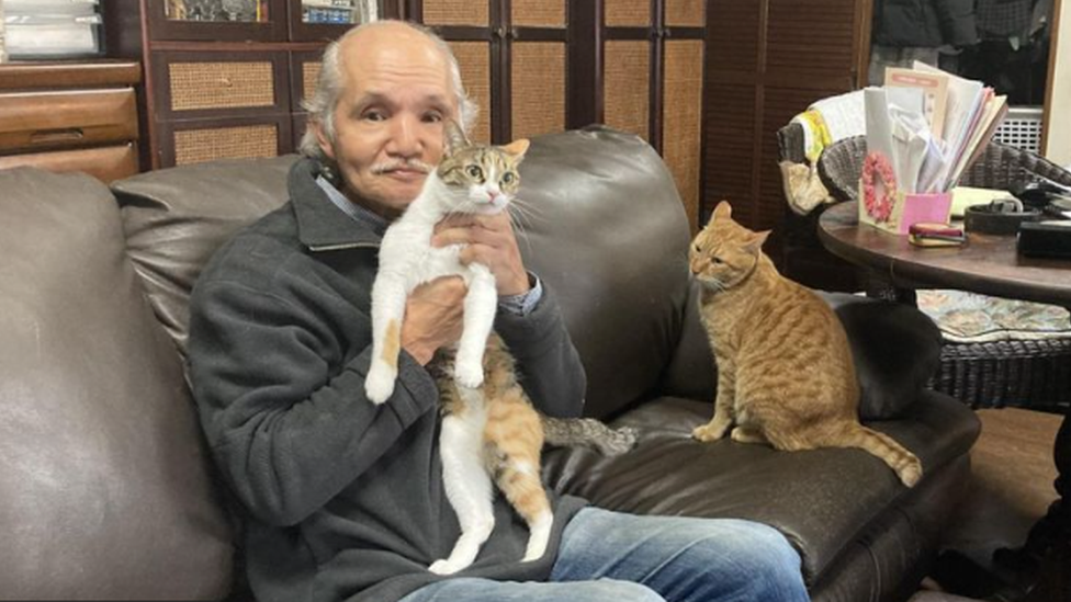 Yoichiro Matsushita con Kiki y Lara, los miembros felinos actuales de su familia.