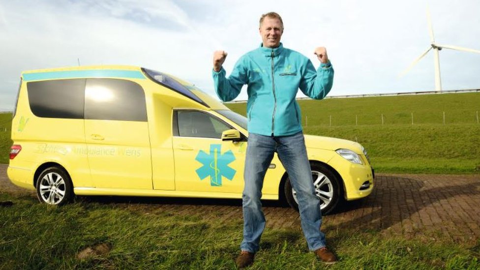 Kees Veldboer standing in front of his ambulance