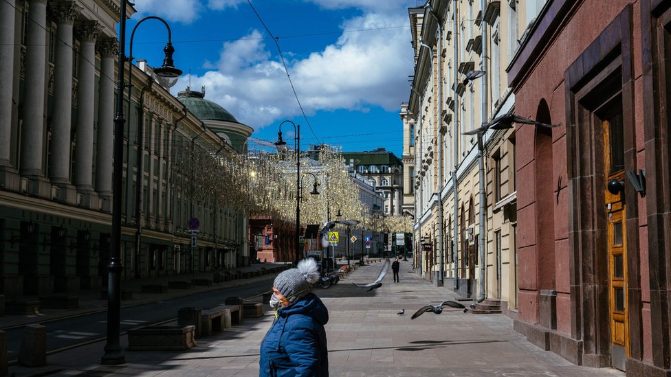 Женщина идет по безлюдной улице в центре Москвы 21 апреля 2020 года