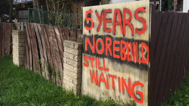 Вывеска возле поврежденного дома в Крайстчерче с надписью «5 лет, без ремонта, все еще ждем»