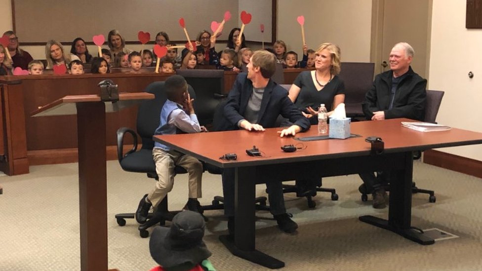 Niños agitan corazones de papel en un tribunal