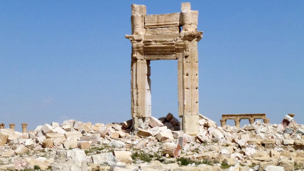 На общем виде видны остатки входа в культовый храм Бэла, который был разрушен джихадистами группы Исламского государства (ИГ) в сентябре 2015 года в древнем городе Пальмира после того, как правительственные войска отбили объект всемирного наследия ЮНЕСКО у группы ИГ на 27 марта 201 г.