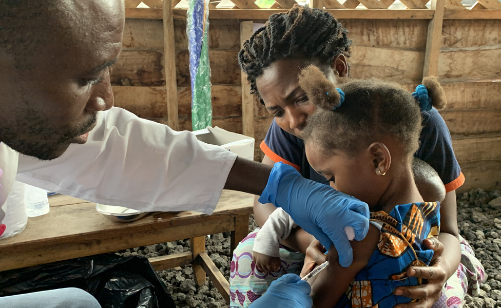 Раздаточная фотография, предоставленная Всемирной организацией здравоохранения (ВОЗ), показывает ребенка, которому делают прививку от кори в медицинском центре в Гоме