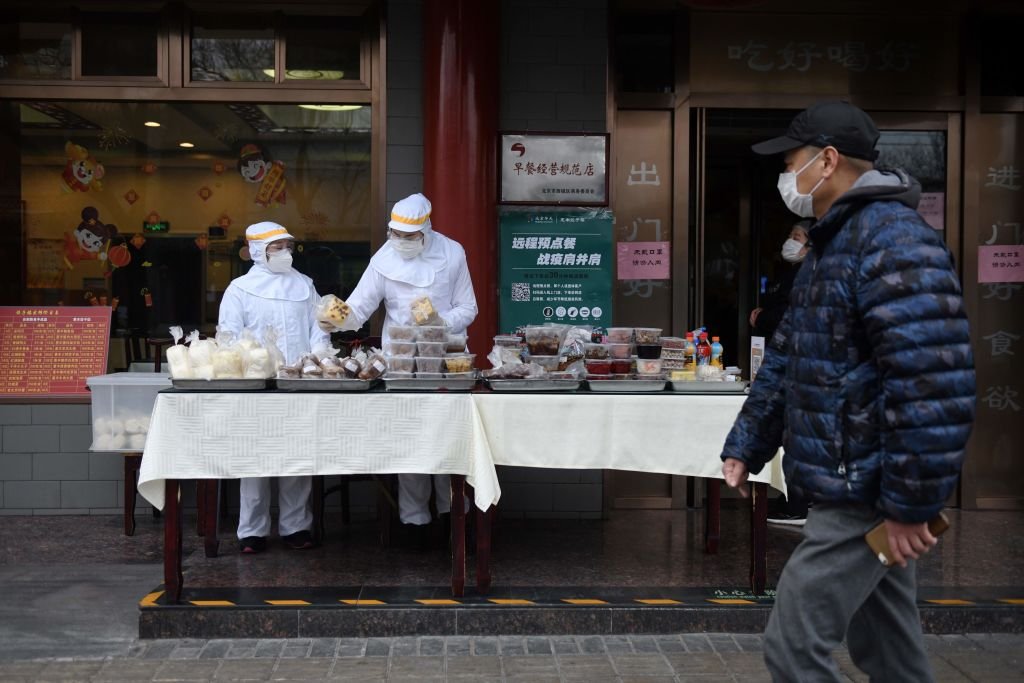 北京街頭一家餐館員工"全副武裝"出售商品。