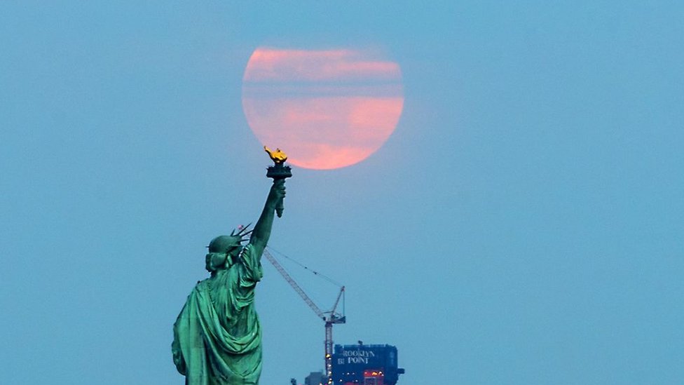 La "súper Luna de gusano" detrás de la Estatua de la Libertad en Nueva York, el 20 de marzo de 2019.