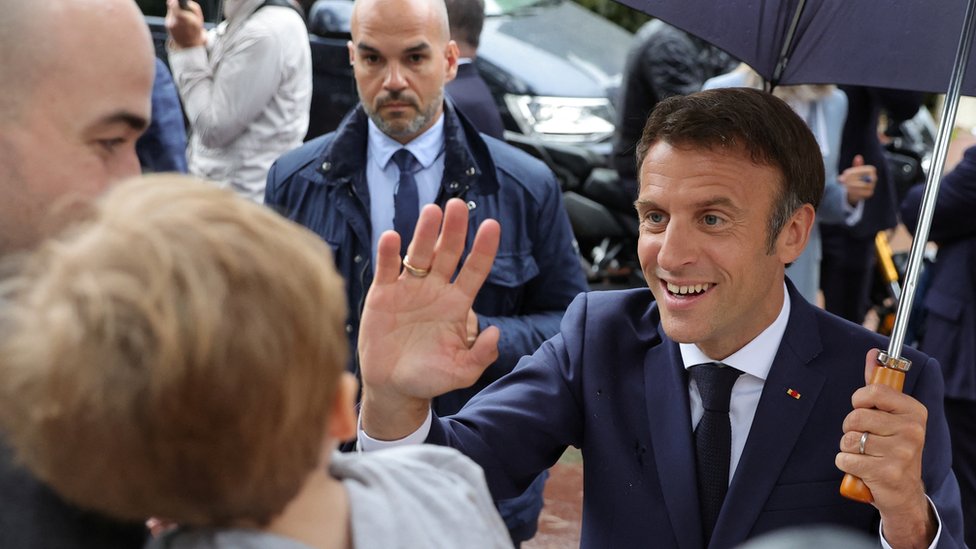 French President Emmanuel Macron greets supporters as he leaves after voting in the second round of French parliamentary elections, at a polling station in Le Touquet-Paris-Plage, France, June 19, 2022.