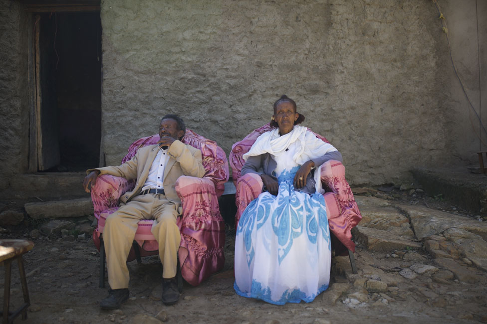 Два человека сидят возле своего дома
