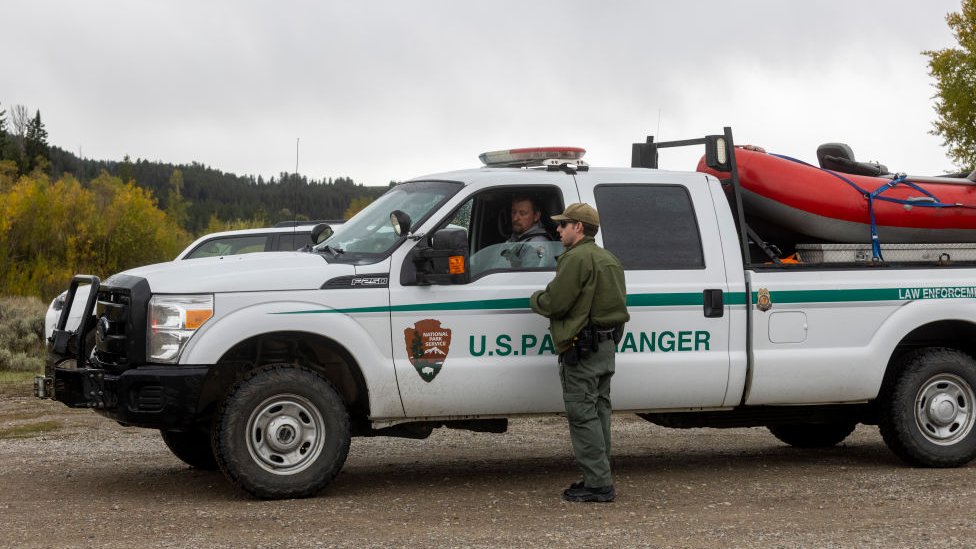 Um guarda florestal fala com um colega na estrada para o acampamento Spread Creek em 19 de setembro de 2021, perto de Moran, Wyoming