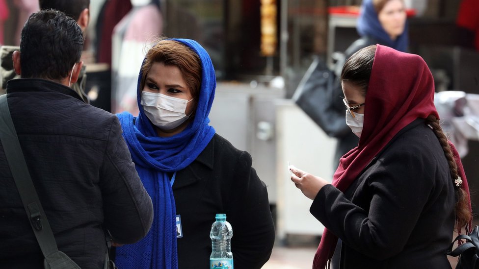 Женщины в масках стоят на улице в Тегеране, Иран (26 февраля 2020 г.)