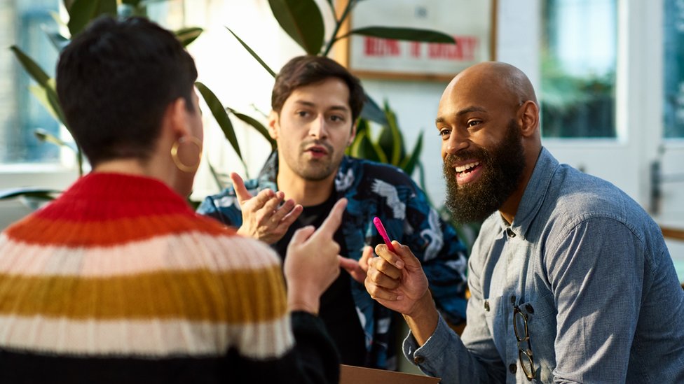 Un grupo de colegas charlando en un lugar de trabajo