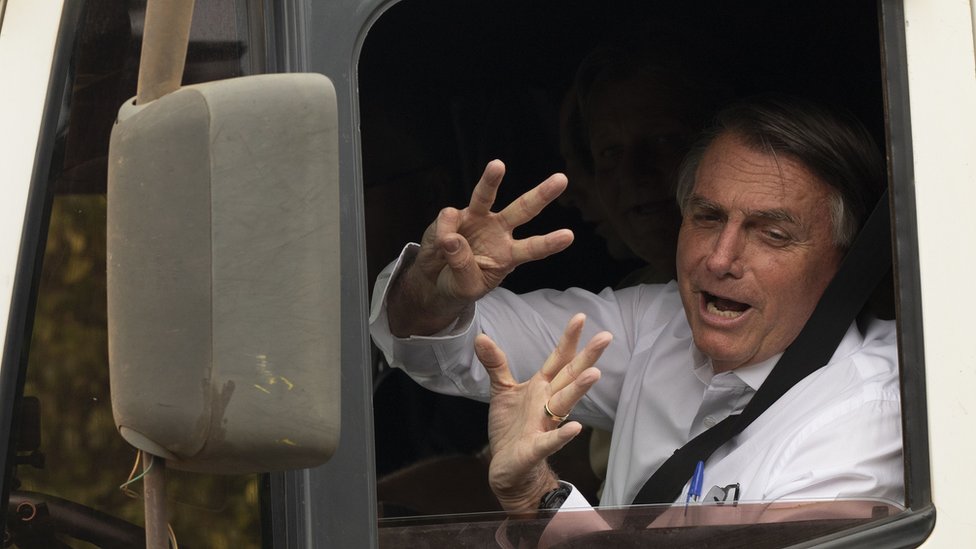 Jair Bolsonaro acenando de dentro de caminhão
