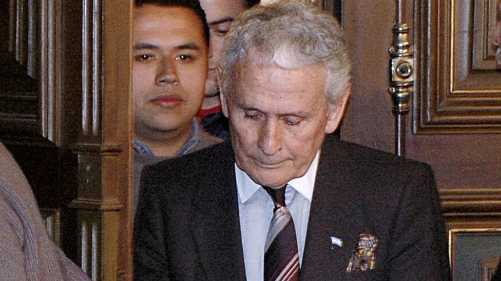 Мигель Эчеколатц (в центре) прибывает на первые слушания по делу о похищении, пытках и убийствах, связанных с его ролью во время военной диктатуры 1976–1983 годов, первым подобным судебным процессом в Аргентине, 20 июня 2006 года в Ла-Плате.
