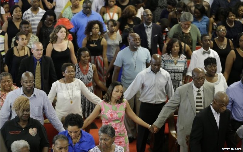 Прихожане обнимаются, посещая первую церковную службу через четыре дня после массового расстрела, унесшего жизни девяти человек в исторической африканской методистской церкви Эмануэля 21 июня 2015 года в Чарлстоне, Южная Каролина