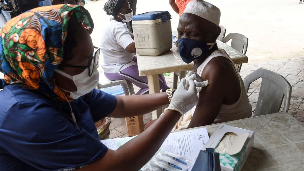 Una enfermera vacuna a un hombre en Nigeria