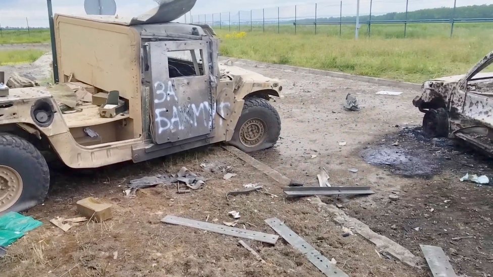 A wrecked vehicle with the words "for Bakhmut" written in Russian on the side