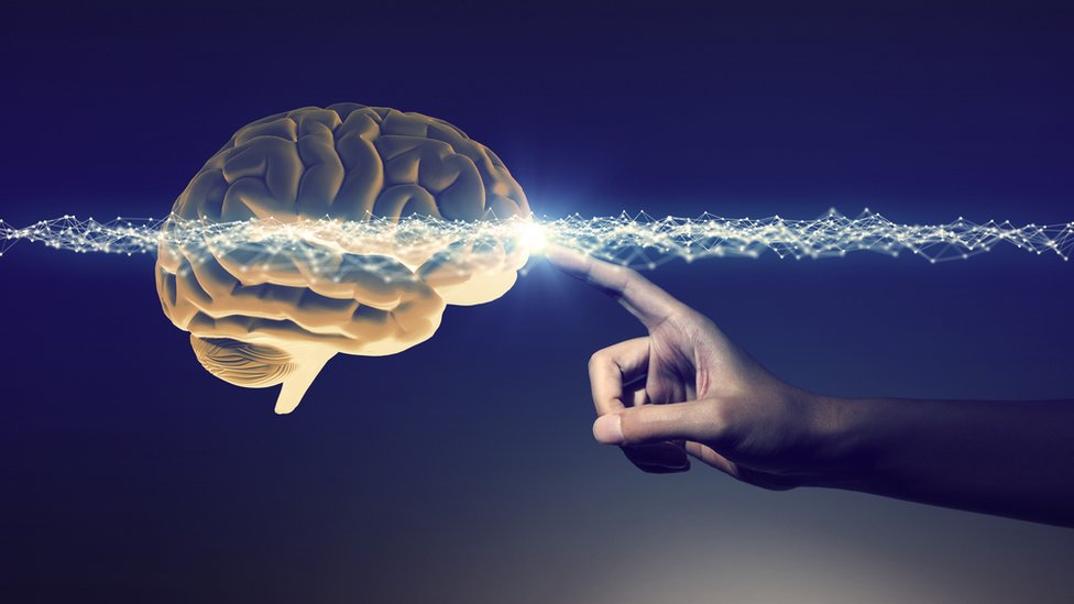 Imagen de un cerebro artificial tocado por una mano y un halo de luz brillante.
