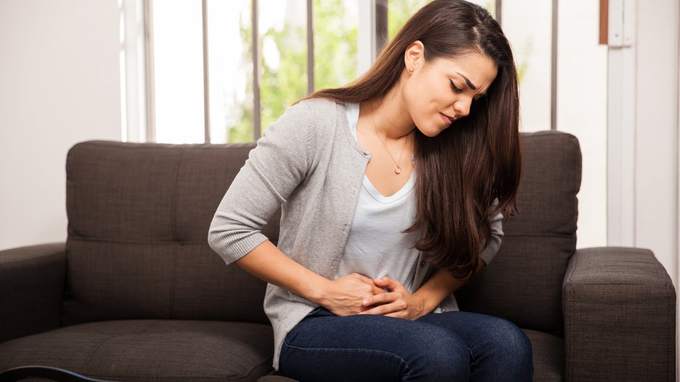 Mujer joven con dolor en la barriga