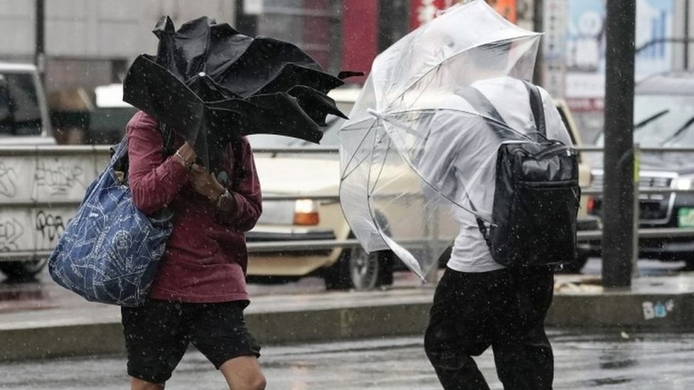 Two pedestrians (not the homeless people in question) brave the storm on Saturday in Tokyo