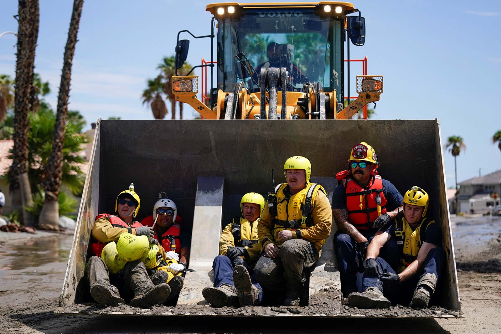 Firefighters and emergency medical personnel ride in construction equipment to locate and rescue residents of a care home after Tropical Storm Hilary in Cathedral City, California - 21 August, 2023.