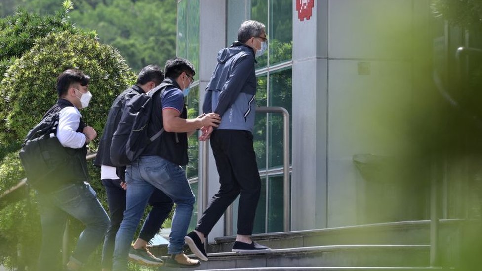 香港警方國安處便裝警員把壹傳媒行政總裁張劍虹（中）押入壹傳媒總部大樓（17/6/2021）