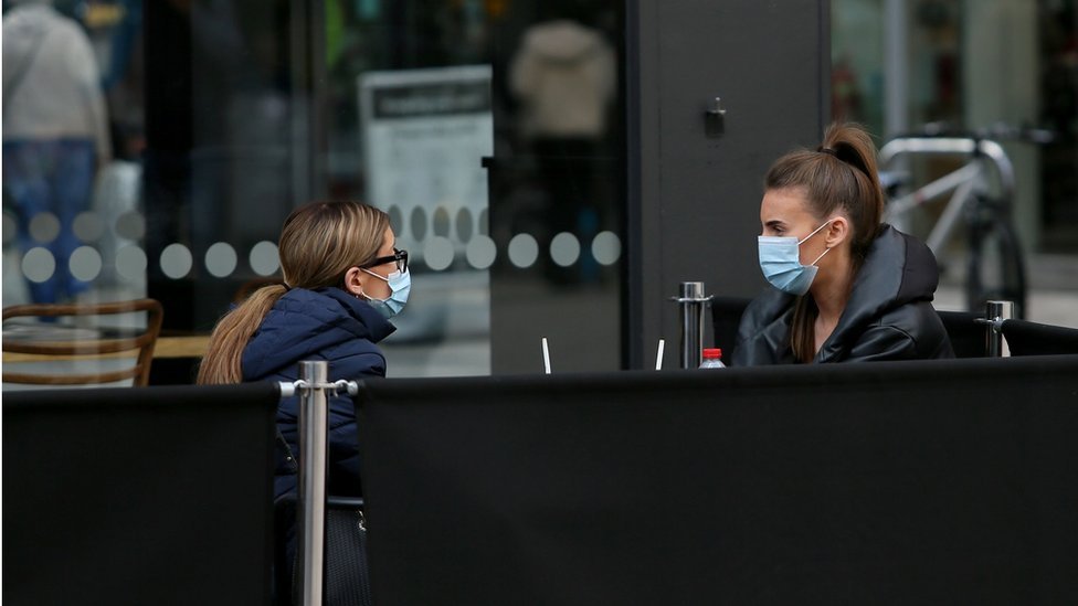 Two people wearing masks outside a cafe in Northern Ireland