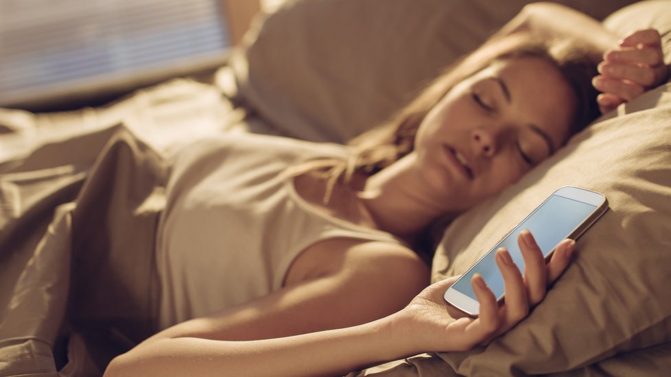 woman asleep holding mobile phone