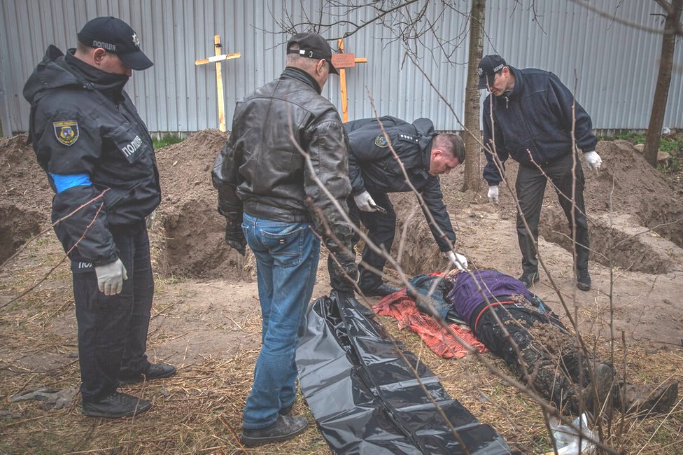 Police in Bucha examine a body unearthed in a field. At least 500 dead have been found since the Russians left