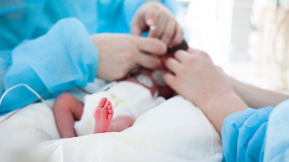 ممرضة تعتني بطفل حديث الولادة