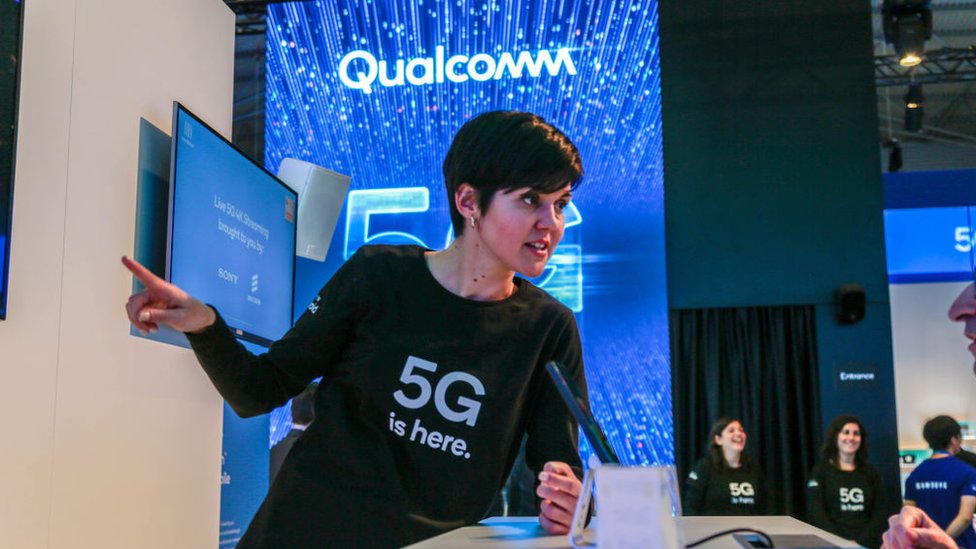 Сотрудник рассказывает о 5G на стенде Qualcomm на Mobile World Congress 2019 в Барселоне