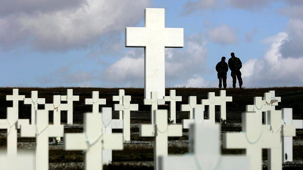 Два члена британской армии смотрят на Гусь-Грин с аргентинского мемориального кладбища в Дарвине на Фолклендских островах