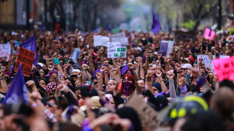 Женщины поднимают кулаки во время акции протеста в Международный женский день в Мексике