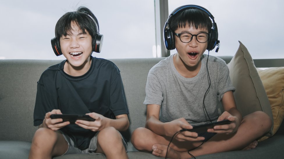 Meninos chineses jogando videogame