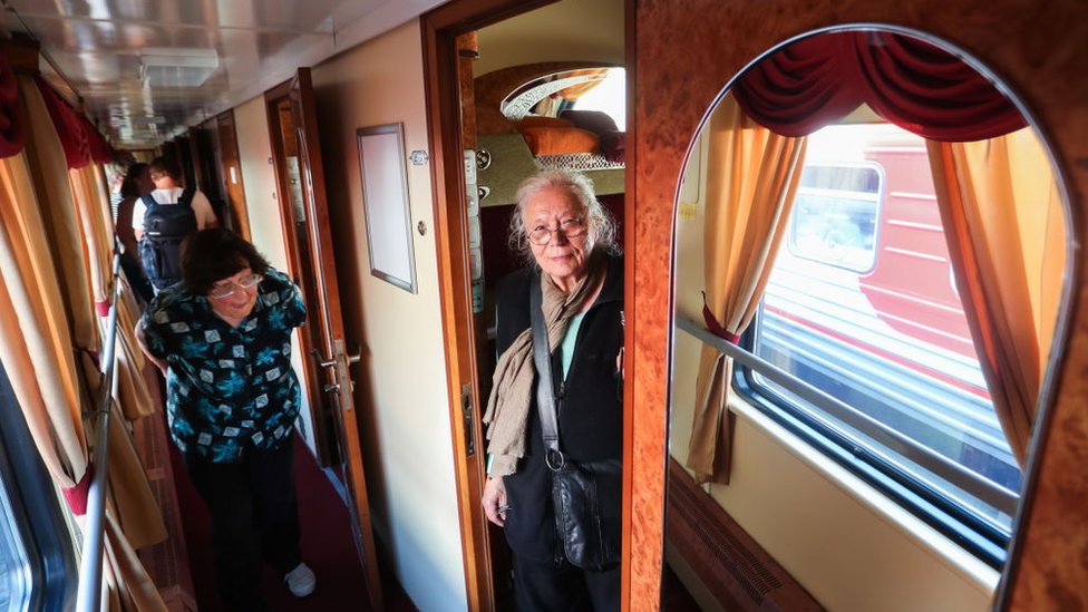 Dos mujeres, en los pasillos del tren. Una de ellas se asoma desde su camarote. Dos mujeres, en los pasillos del tren. Una de ellas se asoma desde su camarote.