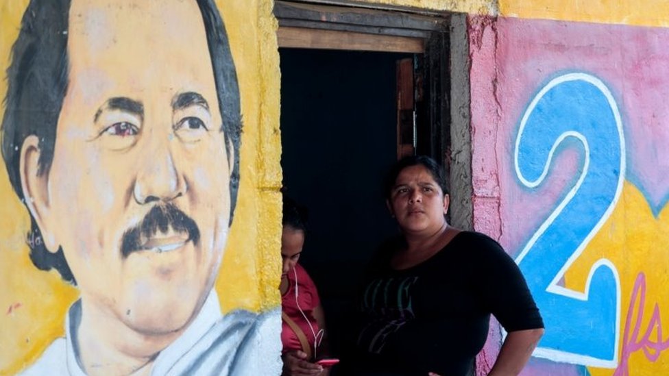 Женщина сидит рядом с изображением президента Никарагуа Даниэля Ортеги в Катарине, Никарагуа, 1 октября 2020 г.REUTERS